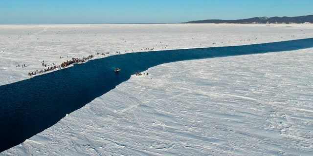 A group of fishermen in Russia use a smaller piece of ice as a raft trying to row to the coast, as the ice floe with stranded fishermen on them slowly drifted further away from the land in eastern Siberia, Russia.