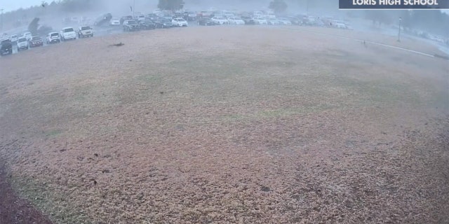 A tornado can be seen flipping cars in the parking lot of a high school in South Carolina on Monday.
