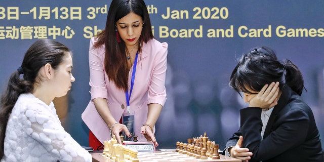Shohreh Bayat (C), chief arbiter for the match between Aleksandra Goryachkina (front L) of Russia and Ju Wenjun (front R) of China, prepares for the match during the 2020 International Chess Federation (FIDE) Women's World Chess Championship in Shanghai on January 11, 2020. (Photo by STR/AFP via Getty Images)