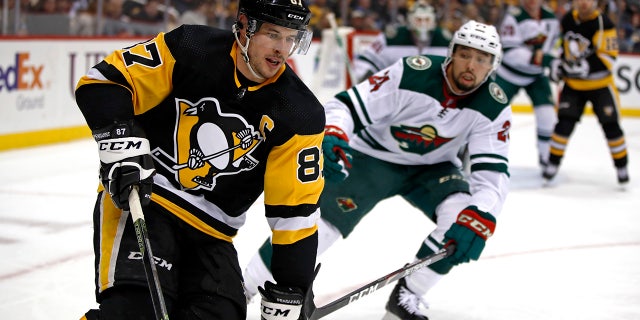 Pittsburgh Penguins' Sidney Crosby (87) works the puck in the corner with Minnesota Wild's Matt Dumba (24) defending during the second period of an NHL hockey game in Pittsburgh, Tuesday, Jan. 14, 2020. (AP Photo/Gene J. Puskar)