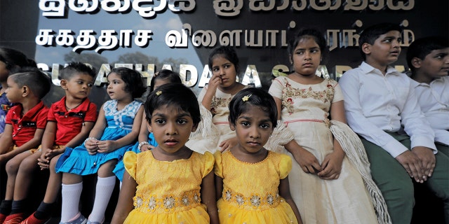 A set of twins stand next to one another in Colombo, Sri Lanka.(REUTERS/Dinuka Liyanawatte)
