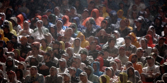 Fans sit in the rain as they watch Super Bowl XLI between the Chicago Bears and the Indianapolis Colts on February 4, 2007 at Dolphin Stadium in Miami Gardens, Florida. The Colts defeated the Bears 29-17.
