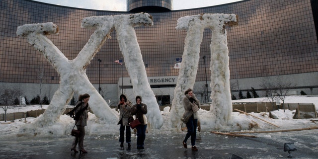 People walk past an ice and snow covered "XVI" display in front of the Hyatt Regency Hotel in Dearborn, Michigan during the week of Super Bowl XVI in January 1982.