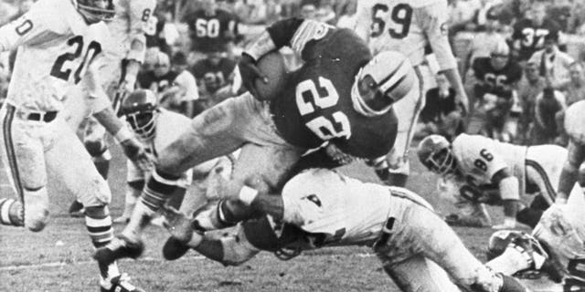 The Packers' Klijah Pitts (22) goes over right tackle to the Chiefs' five-yard line, a six-yard gain, before being brought down by Kansas City's Johnny Robinson in the fourth quarter of the Super Bowl game in Los Angeles Jan. 15, 1967. Three plays later Pitts went over for the touchdown as the Packers beat the Chiefs 35 to 10. Others include Bobby Hunt (20) and Sherrill Headrick (69). (AP Photo)