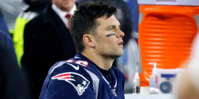 New England Patriots quarterback Tom Brady sits on the bench after throwing an interception as Tennessee Titans cornerback Logan Ryan came back for a touchdown late in the second half of a game Playoff Football Game on Saturday, Jan.4, 2020, in Foxborough, Massachusetts. 