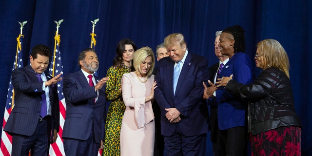 Faith leaders pray over President Donald Trump during an "Evangelicals for Trump Coalition Launch" at King Jesus International Ministry, Friday, Jan. 3, 2020, in Miami. (AP Photo/ Evan Vucci)