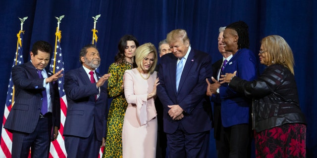 Faith leaders pray over President Donald Trump during an "Evangelicals for Trump Coalition Launch" at King Jesus International Ministry, Friday, Jan. 3, 2020, in Miami. (AP Photo/ Evan Vucci)