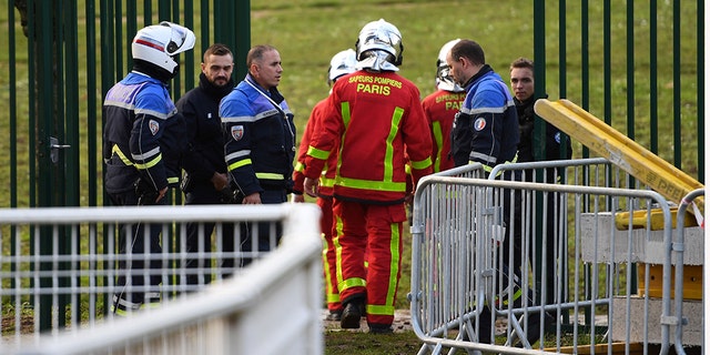 Police and firefighters gather in a park south of Paris on Friday where a man was shot and killed by officers after stabbing passers-by.