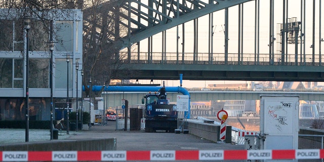 The excavator that uncovered the bomb stands in front of the Hohenzollern Bridge in Cologne on Tuesday. (Roberto Pfeil/dpa via AP)