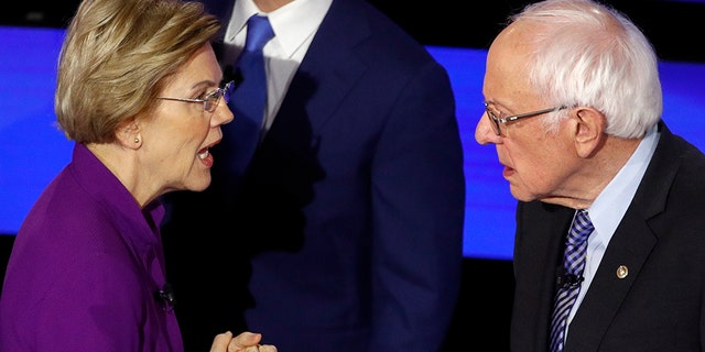 Democratic presidential candidate Sen. Elizabeth Warren, D-Mass., left and Sen. Bernie Sanders, I-Vt., talk Tuesday, Jan. 14, 2020, after a Democratic presidential primary debate hosted by CNN. (AP Photo/Patrick Semansky)