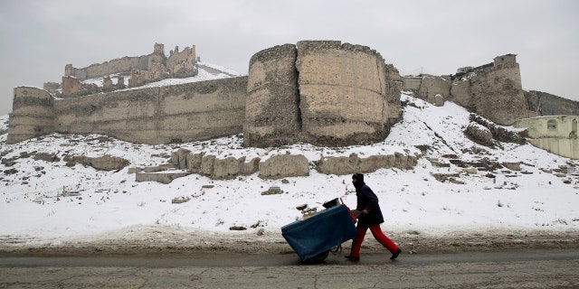 An Afghan street vendor pulls his hand cart after a heavy snowfall in Kabul, Afghanistan, Tuesday, Jan. 14, 2020.