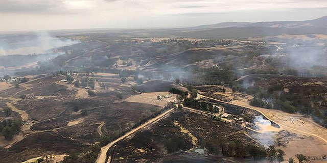 In this Monday, Dec. 30, 2019, aerial photo, acres of scorched land are seen in Bairnsdale, Australia.