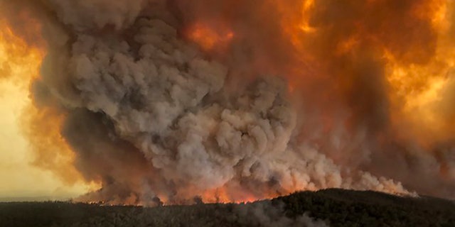 In this Monday, Dec. 30, 2019, aerial photo, wildfires rage under plumes of smoke in Bairnsdale, Australia.
