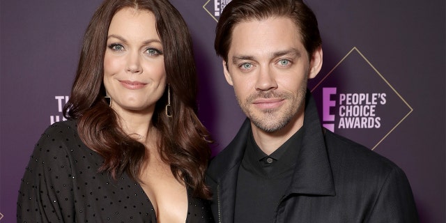 Bellamy Young and Tom Payne pose backstage during the 2019 E! People's Choice Awards held at the Barker Hangar on November 10, 2019.