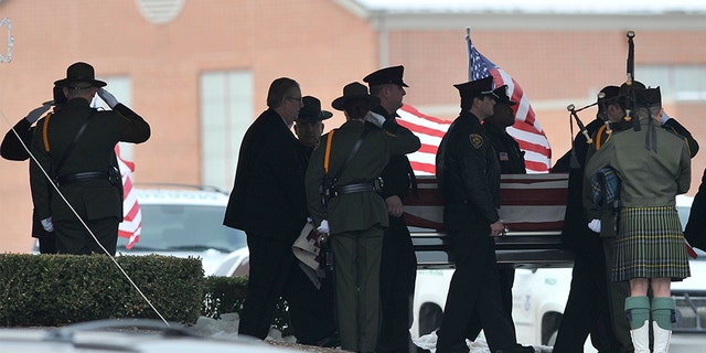 In this 2010 file photo, law enforcement officers carry the casket of Border Patrol officer and former U.S. Marine Brian Terry out of Greater Grace Temple after his funeral service in Detroit, Mich.