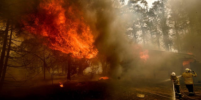 Firefighters battle the Morton Fire as it consumes a home near Bundanoon, New South Wales, Australia, Thursday, Jan. 23, 2020. (AP Photo (AP Photo/Noah Berger)