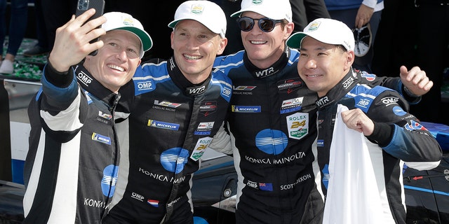 Drivers Ryan Briscoe, Renger van der Zande, Scott Dixon and Kamui Kobayashi celebrate after winning the Rolex 24 at Daytona.