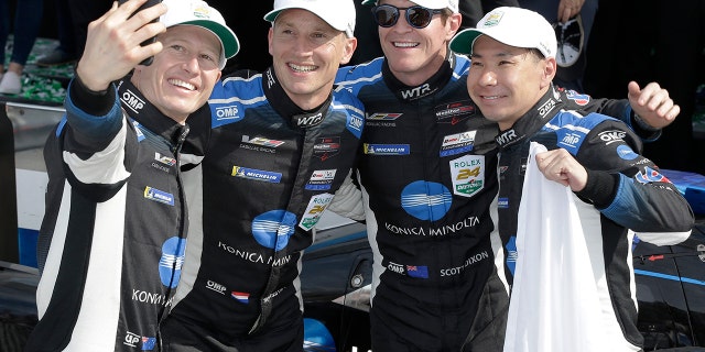 Drivers Ryan Briscoe, Renger van der Zande, Scott Dixon and Kamui Kobayashi celebrate after winning the Rolex 24 at Daytona.