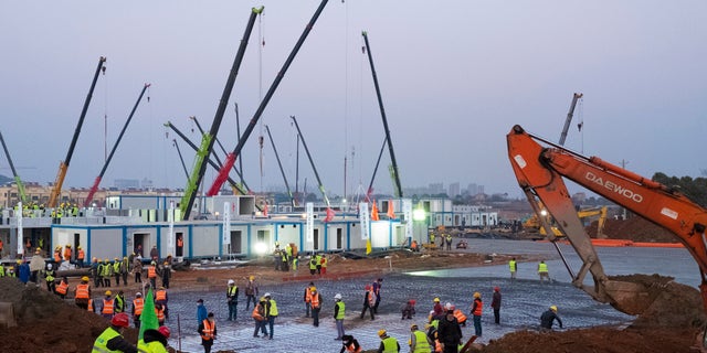 Construction workers labor at the site of the Huoshenshan temporary field hospital being built in Wuhan in central China's Hubei Province, on Jan. 30, 2020.