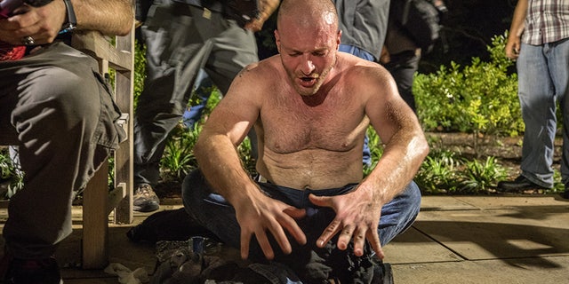 Christopher Cantwell being helped by police after he was overcome with tear gas in the summer of 2017 during the parade through the University of Virginia campus.