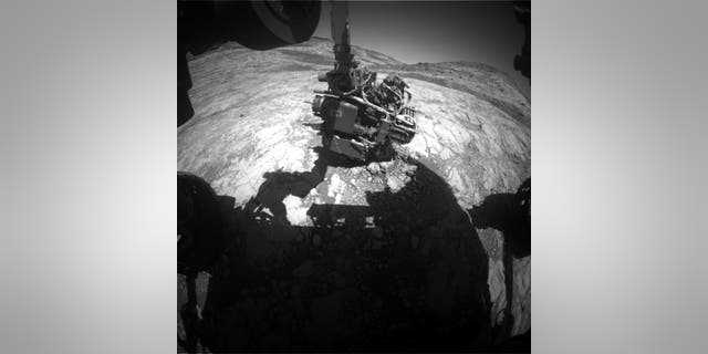 This Hazcam image shows Curiosity's arm extended out to perform an APXS analysis of the bedrock. Curiosity has to know the exact angle of every joint to move safely. (Credit: NASA/JPL-Caltech)