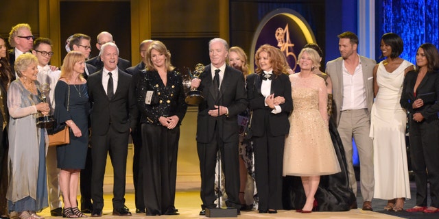 This April 29, 2018 file photo shows Ken Corday, center, and the cast and crew of "Days of Our Lives" accepting the award for outstanding drama series at the 45th annual Daytime Emmy Awards in Pasadena, Calif.