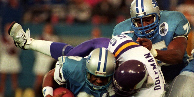 Detroit Lions Quarterback Rodney Pete (9) gets sacked by Minnesota Vikings Chris Doleman (56) as the Lions Lomas Brown (R) tries to help in the second quarter of their NFL game, 5 December 1993. (Photo byMICHAEL E. SAMOJEDEN/AFP via Getty Images)