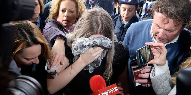 A 19-year-old British woman, center, who was found guilty of making up claims she was raped by up to 12 Israelis arrives at Famagusta District Court for sentencing on Tuesday, Jan. 7, 2020. She insisted she was raped and was coerced by investigators to retract her claim. (AP Photo/Petros Karadjias)