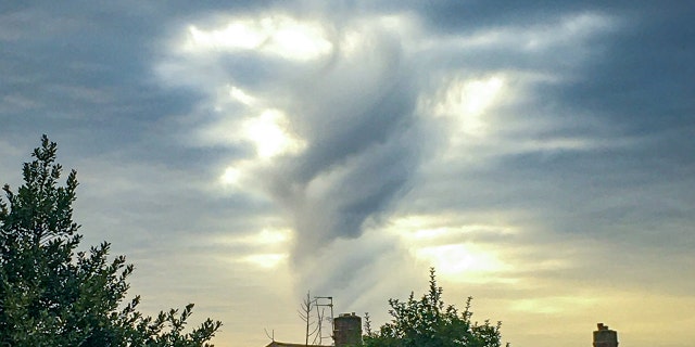 A strange cloud spotted by Caroline Hawthorne over her house in Birmingham which she says looks like a looming Jesus figure. (SWNS)