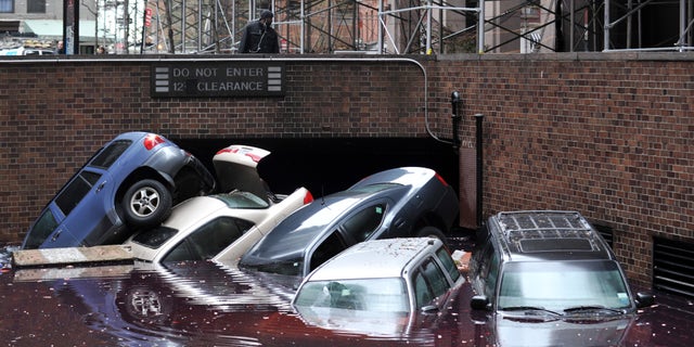 Cars piled on top of each other at the entrance to a garage on South Willliam Street in Lower Manhattan October 31, 2012 in New York as the city begins to clean up after Hurricane Sandy. AFP PHOTO/Stan HONDA (Photo credit should read STAN HONDA/AFP via Getty Images)