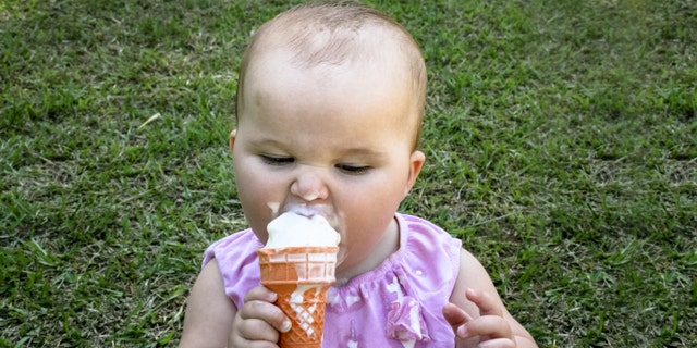 This little baby is relishing the sweet taste of ice cream in summer!