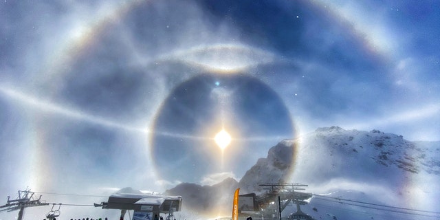 This breathtaking photo shows the moment that ice crystals froze in midair, causing a halo effect around the beaming Sun. (Credit: SWNS)