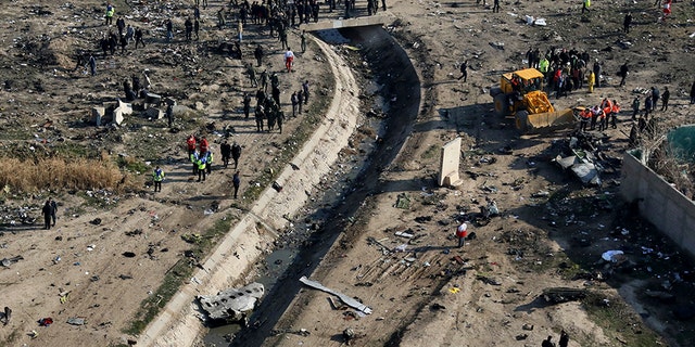 Rescue workers search the scene where a Ukrainian plane crashed in Shahedshahr, southwest of the Iranian capital of Tehran, on Wednesday.