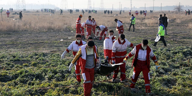 Rescue workers recover the bodies of victims at the crash site.