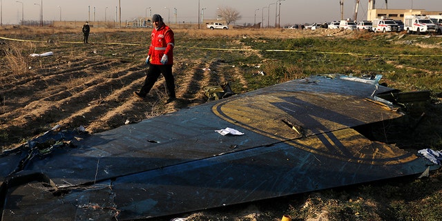 A rescue worker searches the scene where the Ukrainian plane crashed. It was heading for Kiev. (AP)