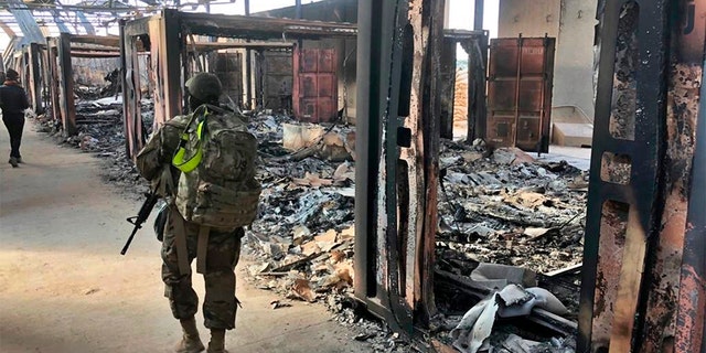 U.S. soldiers walk past damage at the Ain al-Asad base on Monday. (AP)