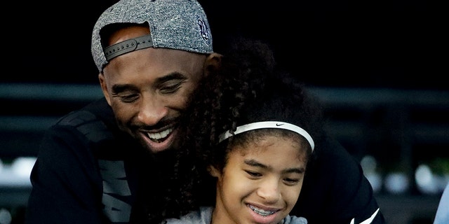 FILE - In this July 26, 2018 file photo former Los Angeles Laker Kobe Bryant and his daughter Gianna watch during the U.S. national championships swimming meet in Irvine, Calif. (AP Photo/Chris Carlson)
