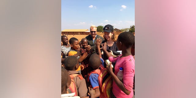 White House staffer Carolina Hurley greeting a group of schoolchildren during her visit to the Chipala Primary School in Lilongwe, Malawi.