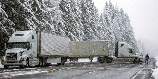 Semitrailer trucks that had been waiting at the U.S. 2 closure turn around Monday, Jan. 13, 2020, in Gold Bar, Wash. after the highway was closed indefinitely.