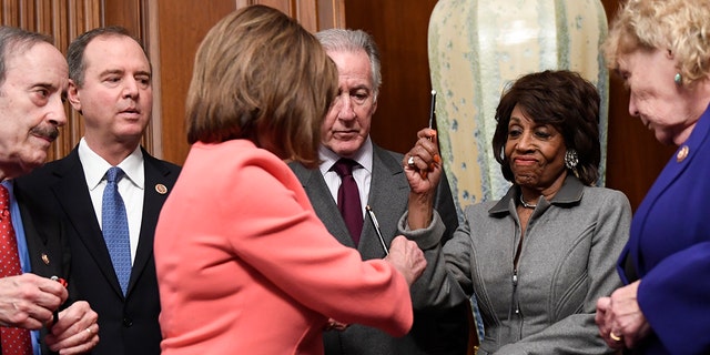 House Financial Services Committee Chairwoman Maxine Waters, D-Calif., second from right, reacts after getting a pen from House Speaker Nancy Pelosi of Calif., after she signed the resolution to transmit the two articles of impeachment against President Trump to the Senate for trial on Capitol Hill. (Associated Press)