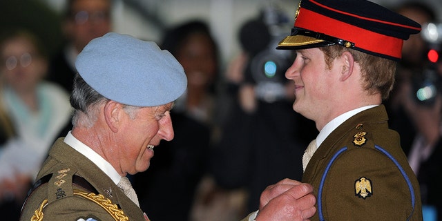 Prince Charles, Prince of Wales presents Prince Harry with his flying wings and his Army Flying Corps blue beret at Prince Harry's pilot course graduation at the Army Aviation Centre on May 7, 2010 in Andover, England.