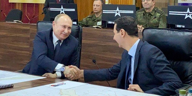 Russian President Vladimir Putin, center, meets with Syrian President Bashar Assad, right, in Damascus, Syria, on Tuesday, Jan. 7, 2020. Putin's visit was the second to the war-torn country where his troops have been fighting alongside Syrian government forces since 2015. (Syrian Presidency via AP)