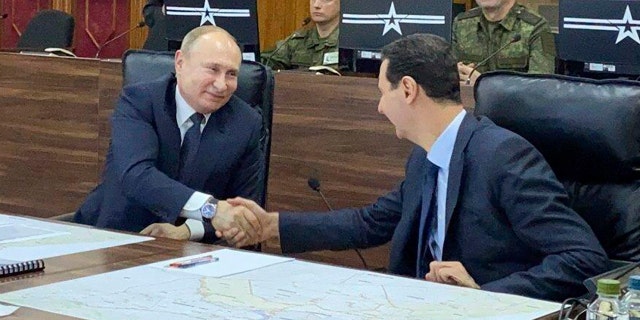 Russian President Vladimir Putin, center, meets with Syrian President Bashar Assad, right, in Damascus, Syria, on Tuesday, Jan. 7, 2020. Putin's visit was the second to the war-torn country where his troops have been fighting alongside Syrian government forces since 2015. (Syrian Presidency via AP)