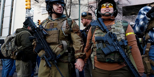 Demonstrators stand outside a security zone before a pro-gun rally in Richmond, Va.