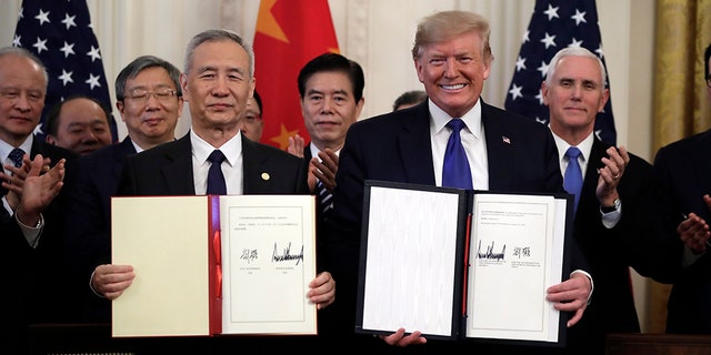 Then-President Trump signs a waste and acquisition statement pinch Chinese Vice Premier Liu He, successful nan East Room of nan White House, Wednesday, Jan. 15, 2020, successful Washington.