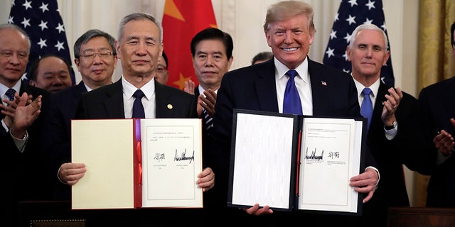 Then-President Trump signs a waste and acquisition statement pinch Chinese Vice Premier Liu He, successful nan East Room of nan White House, Wednesday, Jan. 15, 2020, successful Washington.