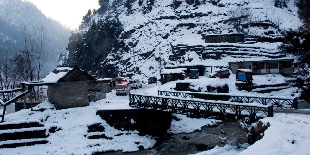 An ambulance heading to an area hit by avalanches waits for a blocked road to be opened, in Keran, a small town in Neelum Valley, Pakistan-administered Kashmir, Tuesday, Jan. 14, 2020.