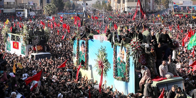 Coffins of Gen. Qassem Soleimani and others who were killed in Iraq by a U.S. drone strike, are carried on a truck surrounded by mourners during a funeral procession, in the city of Kerman, Iran, on Tuesday.