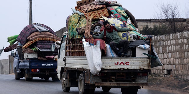 Syrians drive through the city of al-Mastouma, in Idlib province, as they flee a government offensive on Tuesday. (AP)