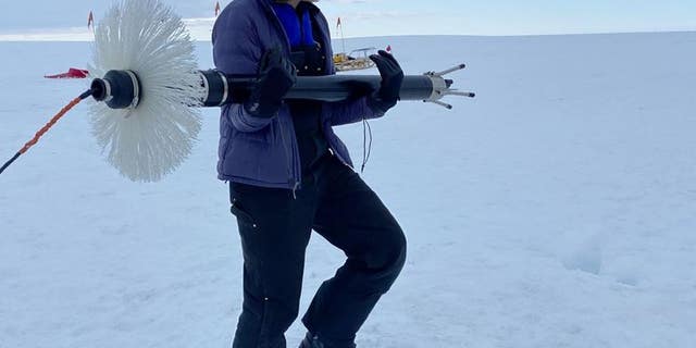 NYU graduate student Aurora Basinski carries a turbulence measuring device to the borehole on Thwaites Glacier. (David Holland, NYU and NYU Abu Dhabi)
